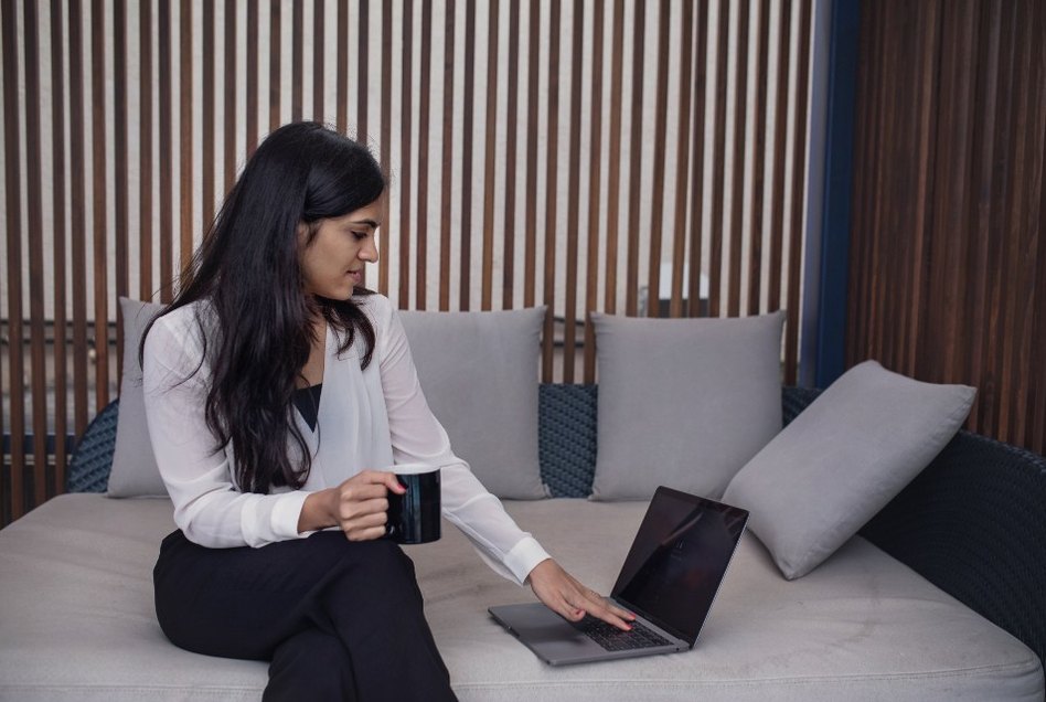 A small business owner reading her dashboard over coffee with her laptop in the morning